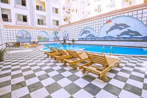 a pool in a building with chairs and a swimming pool at Rare New Marina Hotspot With Fast Free WIFI, Balcony & Pool - Western Standards - Sheraton Plaza 414 in Hurghada
