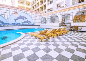 a pool with a group of chairs and a swimming pool at Rare New Marina Hotspot With Fast Free WIFI, Balcony & Pool - Western Standards - Sheraton Plaza 414 in Hurghada