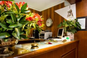 an office with a desk with flowers and a computer at Albergo Marin in Venice
