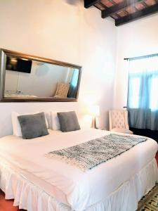 a bedroom with a large white bed with a mirror at La Terraza de San Juan in San Juan