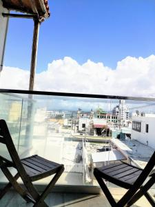 a chair on a balcony with a view of a city at La Terraza de San Juan in San Juan