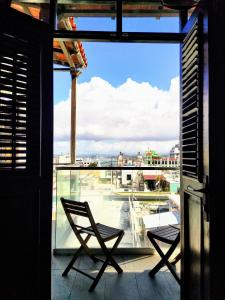 two chairs on a balcony with a view of a city at La Terraza de San Juan in San Juan