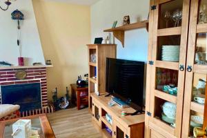 a living room with a television and a fireplace at LaCasitadelaPraderapuntoes in Torremocha de Jarama