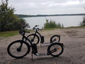dos bicicletas están estacionadas junto a un cuerpo de agua en Gastenkamers in vakantiewoning CasaCuriosa, en Mol