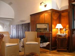 a living room with chairs and a television and a lamp at Appartamenti LEON D'ORO in Riva del Garda