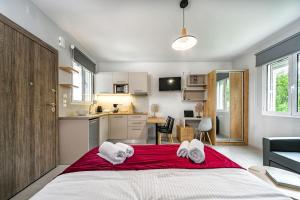 a bedroom with a large bed and a kitchen at Elia Tree Studios in Heraklio Town