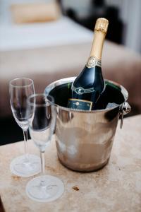 a bottle of champagne in a bucket next to two glasses at Elite Eden Park Hotel in Stockholm