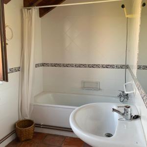 a bathroom with a white tub and a sink at Casa Cuco in Serdio