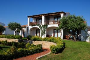 una grande casa bianca con alberi e un cortile di Le Tre Querce a San Teodoro