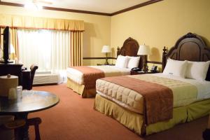 a hotel room with two beds and a table at Folk Inn Ontario Airport in Ontario