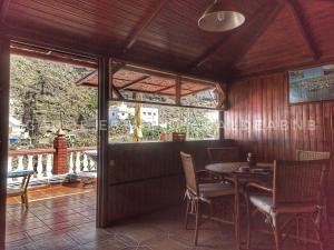 a dining room with a table and chairs and a balcony at Vv CASA JULIANA- Coqueta casa entre montañas. in La Aldea de San Nicolas