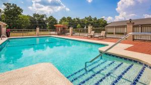 a swimming pool with blue water in a yard at Best Western TimberRidge Inn in Grove