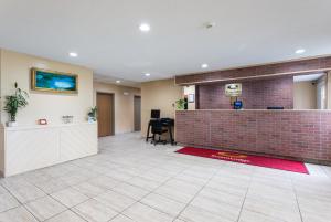 an office lobby with a reception desk and a brick wall at Econo Lodge Painted Post - Corning in Painted Post