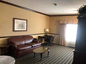 a hotel room with a couch and a desk at Folk Inn Ontario Airport in Ontario