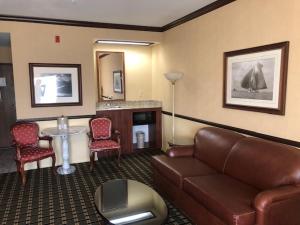 a hotel room with a couch and a table and chairs at Folk Inn Ontario Airport in Ontario