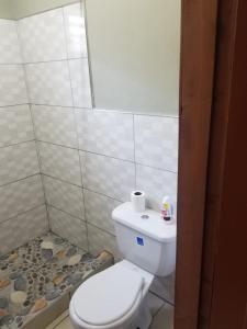 e bagno con servizi igienici bianchi e doccia. di Elizabeth Enchantments a La Ceiba