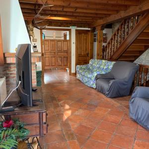 Casa Cuco في Serdio: غرفة معيشة مع تلفزيون وأريكة