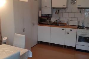 eine kleine Küche mit weißen Schränken und einem Tisch in der Unterkunft Anvar in Düsseldorf
