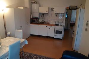 eine kleine Küche mit weißen Schränken, einem Tisch und einem Herd in der Unterkunft Anvar in Düsseldorf