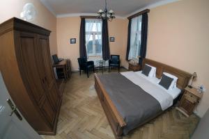 1 dormitorio con 1 cama, escritorio y sillas en Vila U Varhanáře, en Kutná Hora