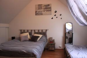 a bedroom with a bed and birds on the wall at Celine'Home in Saint-Germain-sur-Morin