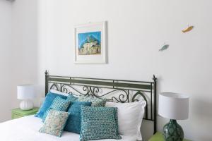 een slaapkamer met een bed met blauwe en witte kussens bij Casa Fló in Salerno