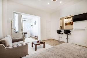 a white living room with a bed and a couch at Viktoria design studio apartment in Budapest