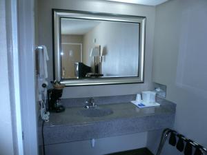 a bathroom with a sink with a large mirror at Executive Inn Kilgore in Kilgore