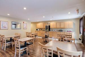 a restaurant with tables and chairs and a kitchen at Econo Lodge Painted Post - Corning in Painted Post