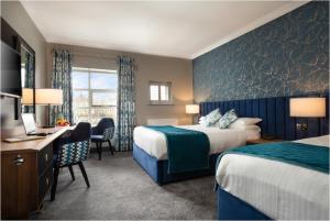 a hotel room with two beds and a desk at The Riverside Park Hotel in Enniscorthy