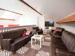 a living room with a couch and a tv at ibis Avallon in Magny