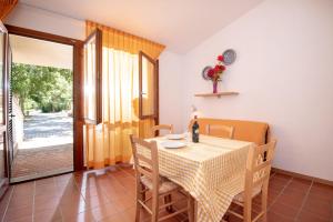 een eetkamer met een tafel en stoelen en een raam bij Ghiacci Vecchi Residence in Venturina Terme