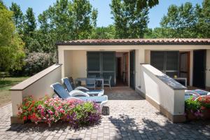 una piccola casa con sedie e patio di Ghiacci Vecchi Residence a Venturina Terme