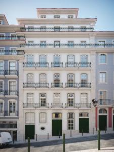 un grand bâtiment blanc avec des portes vertes. dans l'établissement Madalena Orquidea Living Apartments, à Lisbonne