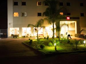 孔塔任宜必思康塔奇撒酒店的夜间在建筑物前行走的人