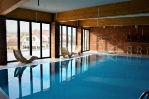 a large swimming pool with chairs in a building at PROSECCO RESIDENCE MARKO in Valtice
