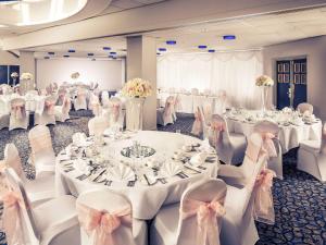 a banquet hall with white tables and chairs with white tablesearcher at Mercure Bolton Georgian House Hotel in Bolton
