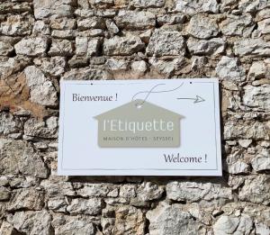 a sign on the side of a stone wall at Maison d'Hôtes L'Etiquette in Seyssel