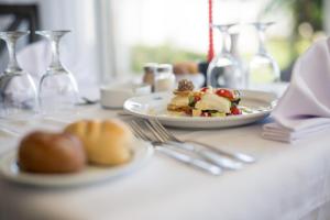 Bizerta Resort Congres & SPA في بنزرت: طاولة مع طبق من الطعام وكؤوس النبيذ