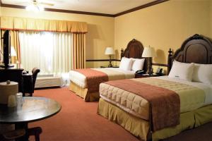 a hotel room with two beds and a table at Folk Inn Ontario Airport in Ontario