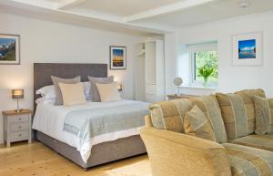 - une chambre avec un lit et un canapé dans l'établissement Hillside Studio, à Penzance