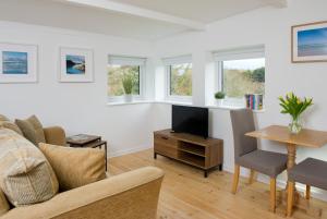 ein Wohnzimmer mit einem Sofa und einem Tisch in der Unterkunft Hillside Studio in Penzance