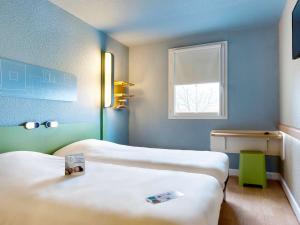 Ein Bett oder Betten in einem Zimmer der Unterkunft ibis budget La Roche Sur Yon Vendespace