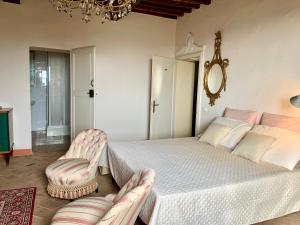 a room with a bed, chair, table and a lamp at Casa Cerboneschi in Casale Marittimo