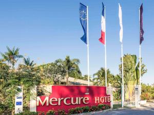 una señal para un hotel mercure con tres banderas en Mercure Cayenne Royal Amazonia en Cayenne