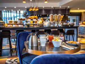 un restaurant avec une table et de la nourriture dans l'établissement Hôtel Mercure Paris Gennevilliers, à Gennevilliers