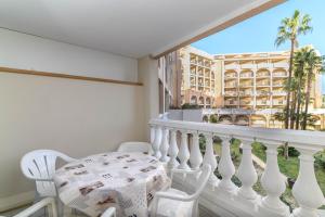 a balcony with a table and chairs and a building at LE PALM AZUR - vue mer sur les iles de Lérins in Cannes
