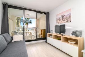 a living room with a couch and a tv at LE PALM AZUR - vue mer sur les iles de Lérins in Cannes