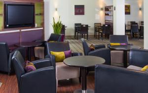 une salle d'attente avec des tables et des chaises et une télévision à écran plat dans l'établissement Holiday Inn Express Stirling, an IHG Hotel, à Stirling