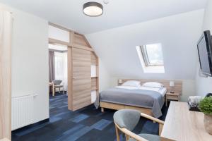 1 dormitorio con 1 cama, mesa y sillas en Nawigator SPA, en Rewal